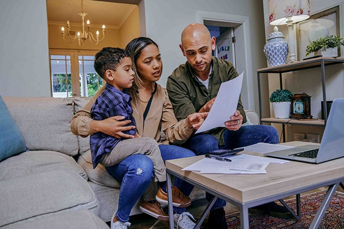 Family of three looking at paper
